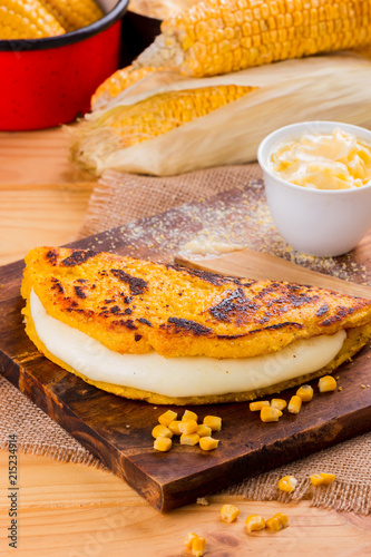 Wooden table with several ingredients for the preparation of Cachapas with cheese, corn, butter, ground corn and white cheese, Venezuelan Cuisine photo