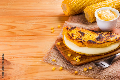 Wooden table with several ingredients for the preparation of Cachapas with cheese, corn, butter, ground corn and white cheese, Venezuelan Cuisine