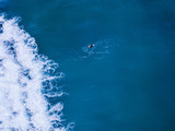 One surfer swimming on top of the surfboard.