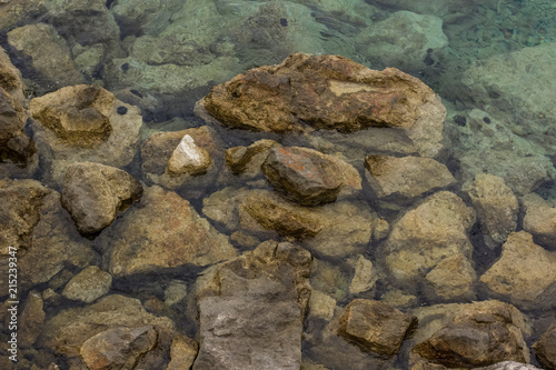 calm rest concept of blue water surface and small waves with stones and empty space for copy or text