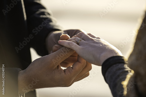 Man putting ring in his woman's finger photo