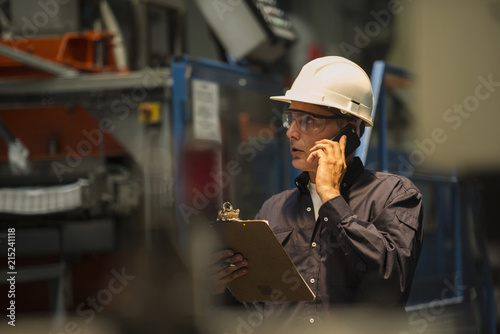 Factory worker using mobile phone in factory