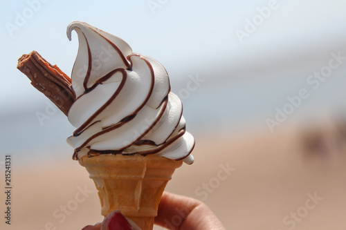 An icecream with a flake and chocolate sauce.