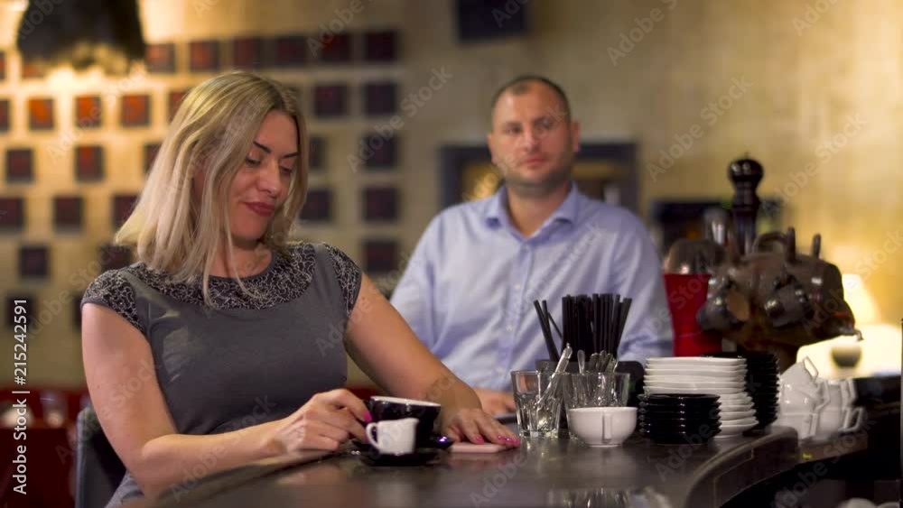 Beautiful woman flirting with handsome man sitting at bar counter in restaurant Beautiful woman flirting with handsome man sitting at bar counter in restaurant