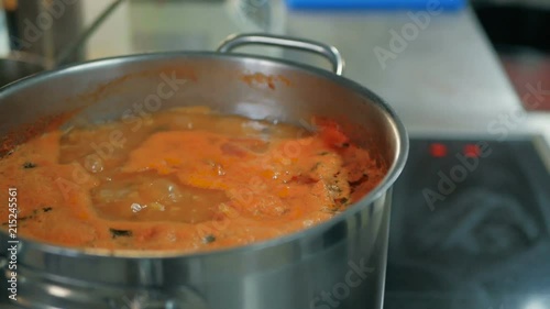 saucepan with boiling soup in the kitchen in a restaurant photo