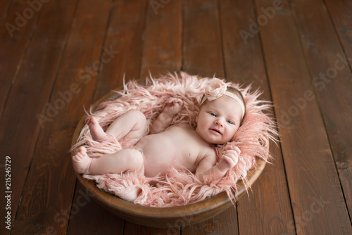 Newborn girl on a brown background. Photoshoot for the newborn. 7 days from birth. A portrait of a beautiful, seven day old, newborn baby girl