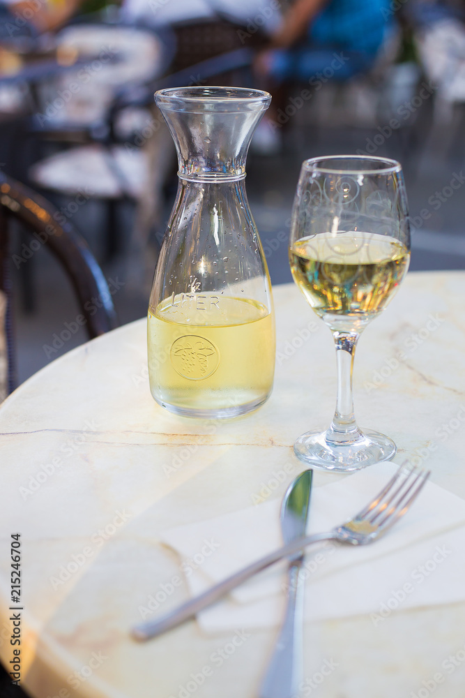 White wine in a liter bottle on a table in a cafe. White wine in a liter bottle on a table in a cafe.