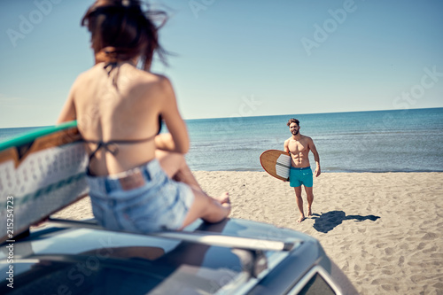 Sporty people with surf boards on the beach - Extreme sport and vacation concept. © luckybusiness