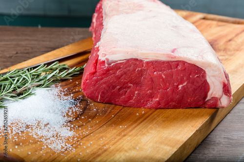 Raw whole beef sirloin on chopping board