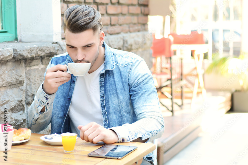 Young man in coffee shop cafe using a tablet. Young man in coffee shop cafe using a tablet.