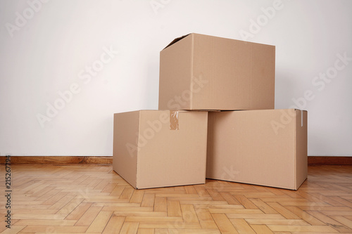Stack of cardboard boxes in the empty room © Mego-studio