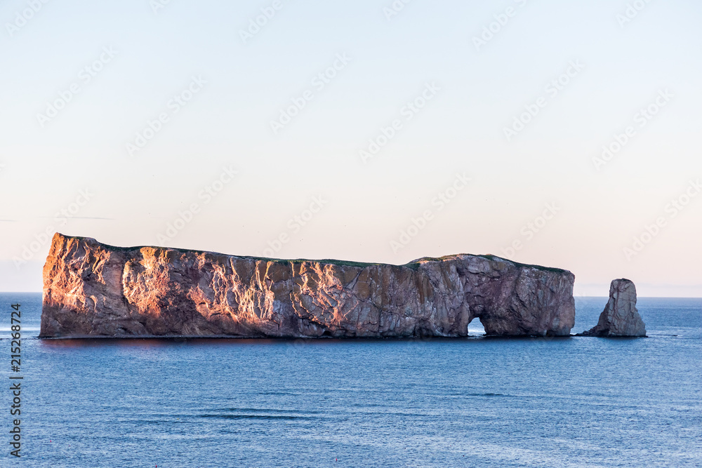 Famous Rocher Perce rock in Gaspe Peninsula, Quebec, Gaspesie region, Canada during sunset, blue Saint Lawrence gulf shadow water