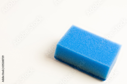 One blue color sponge for dishwashing on white background with copy space. Cleaning concept