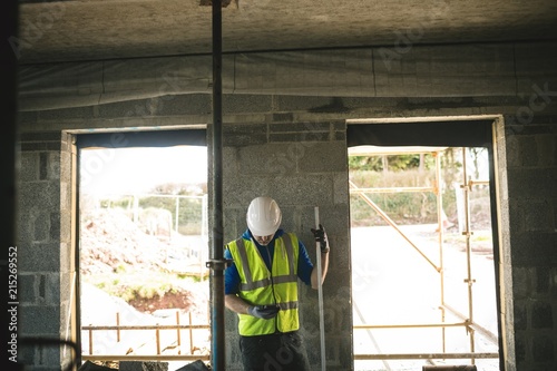 Wallpaper Mural Engineer with level gauge using his phone Torontodigital.ca