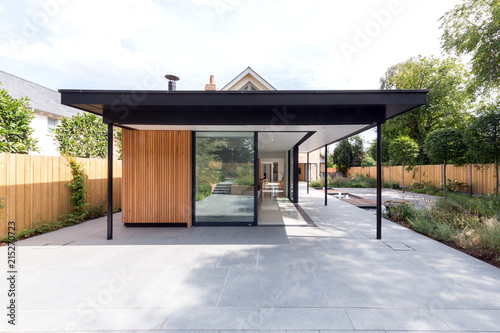 Contemporary mostly glass domestic building set in a designed garden. photo