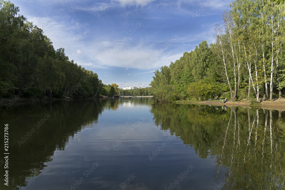 The shores are reflected in the surface of the pond. The shores are reflected in the surface of the pond.