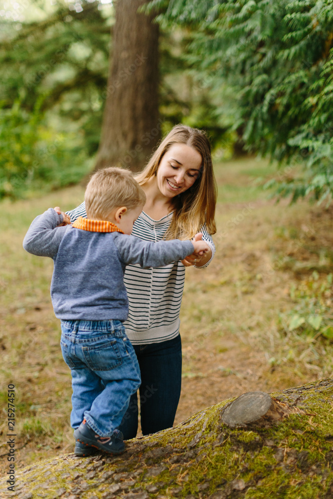 Mother Helping Son Walk on Log Mother Helping Son Walk on Log