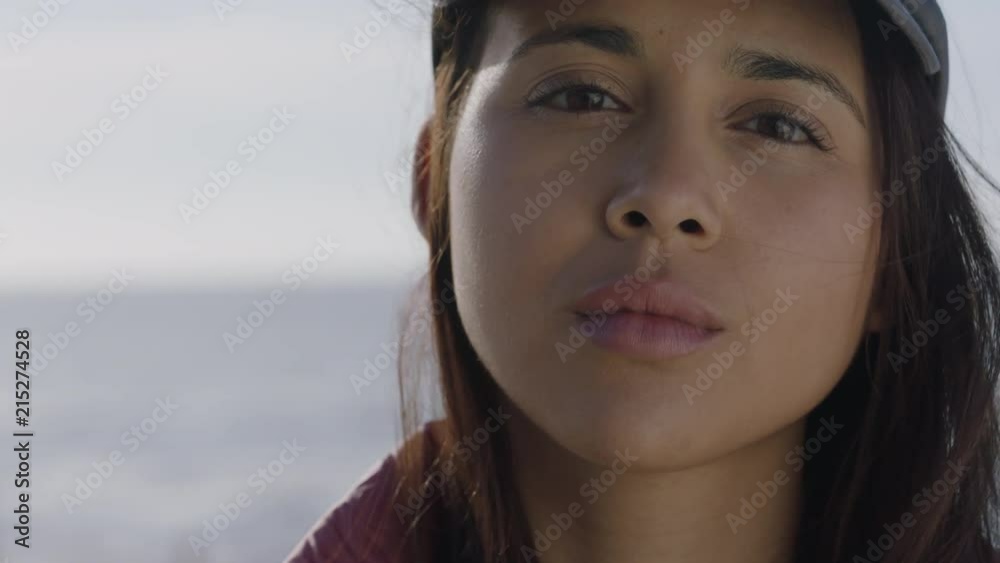 close up portrait of beautiful young hispanic woman looking serious pensive at camera wearing hat on sunny seaside day close up portrait of beautiful young hispanic woman looking serious pensive at camera wearing hat on sunny seaside day