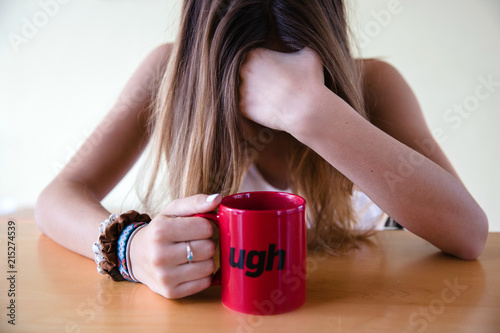 Female with a coffee mug that says ugh photo