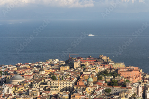 Naples and Mediterranean sea with white boat top view. Naples cityscape on sunset. Travel concept. Aerial italian landscape. Neapol panorama. Vastness and vacation concept.
