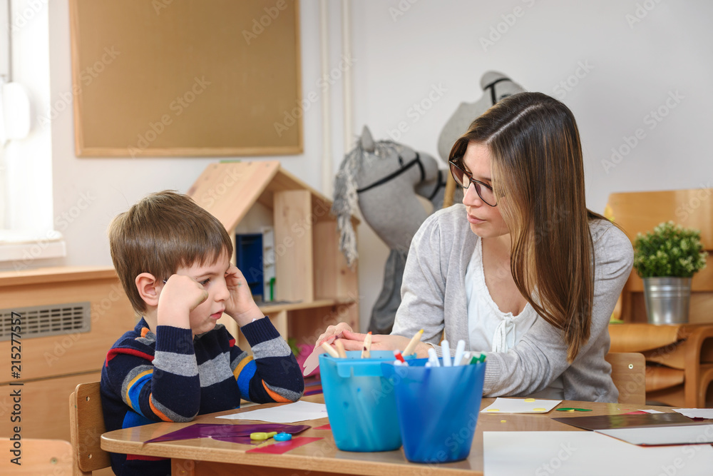 Teacher supports baby boy at kindergarten Teacher supports baby boy at kindergarten