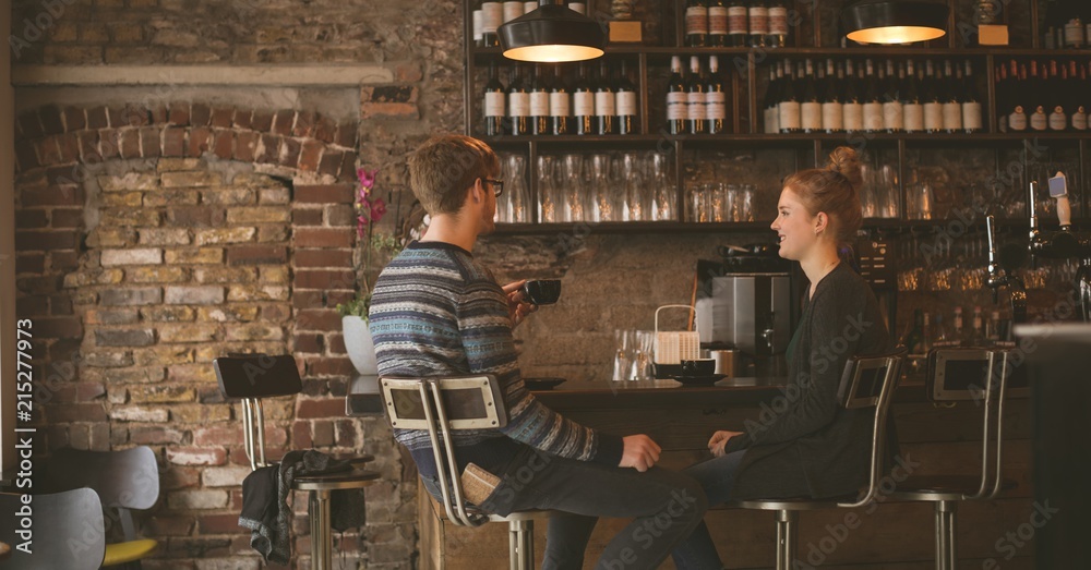 Couple having coffee while sitting at the bar counter Couple having coffee while sitting at the bar counter