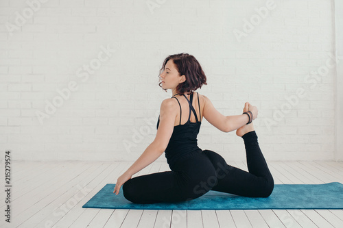 Young woman stretching on mat