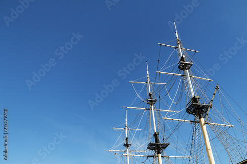 Sea ship masts and ropes against blue sky. Concept of travel, adventure and sea. Copy space.