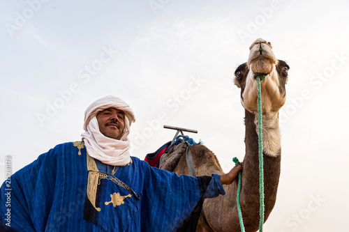 Portrait of a Berber and camel in the Sahara Desert photo