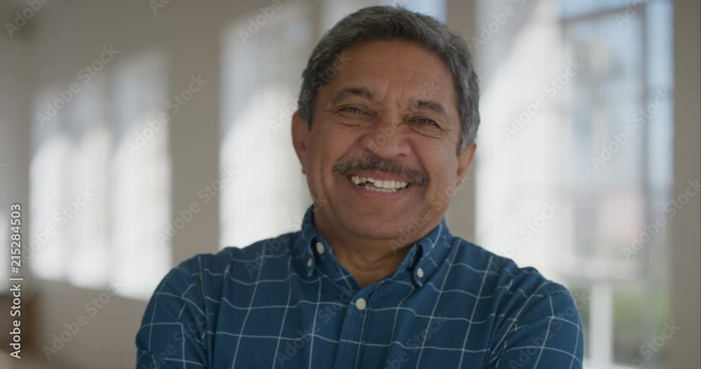 portrait of middle aged hispanic man smiling confident looking at camera cheerful retired mature male enjoying lifestyle wearing blue shirt
