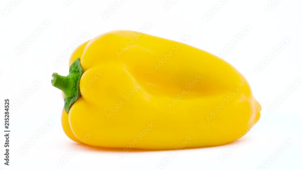 One yellow bell pepper. Rotating on the turntable. Isolated on the white background. Close up. Macro. One yellow bell pepper. Rotating on the turntable. Isolated on the white background. Close up. Macro.