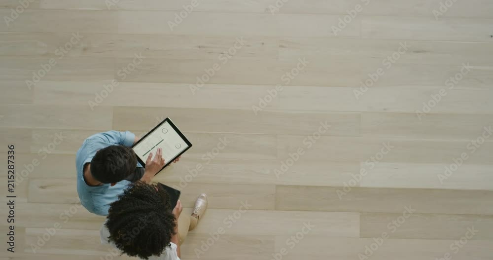 young multi ethnic business team meeting discussing research statistics using graphs on tablet screen technology brainstorming creative ideas working together top view