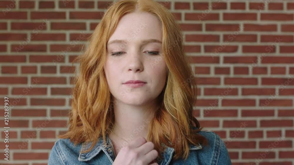portrait of beautiful red head woman looking shy vulnerable on brick wall background portrait of beautiful red head woman looking shy vulnerable on brick wall background