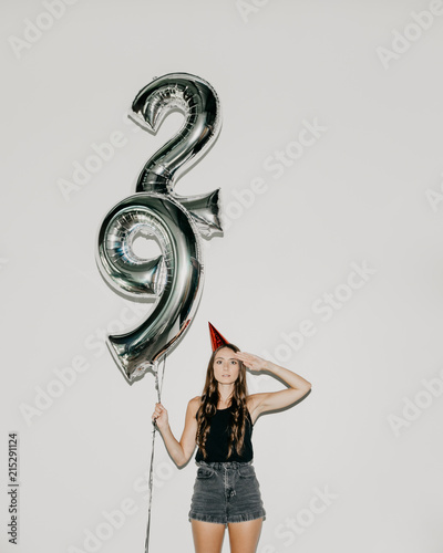 A Woman Holding 29 Number Birthday Balloons photo