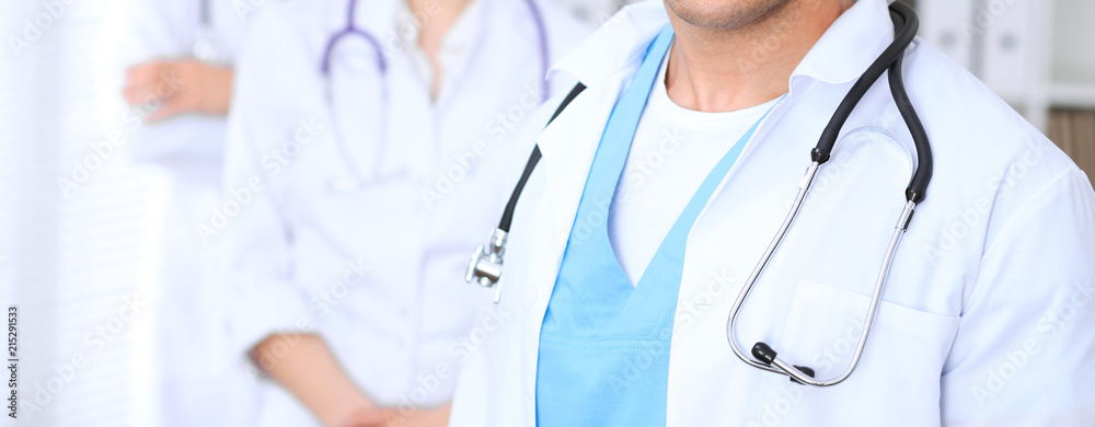 Groupe of unknown doctors standing straight in hospital office. Close Up of stethoscope at practitioner breast Groupe of unknown doctors standing straight in hospital office. Close Up of stethoscope at practitioner breast