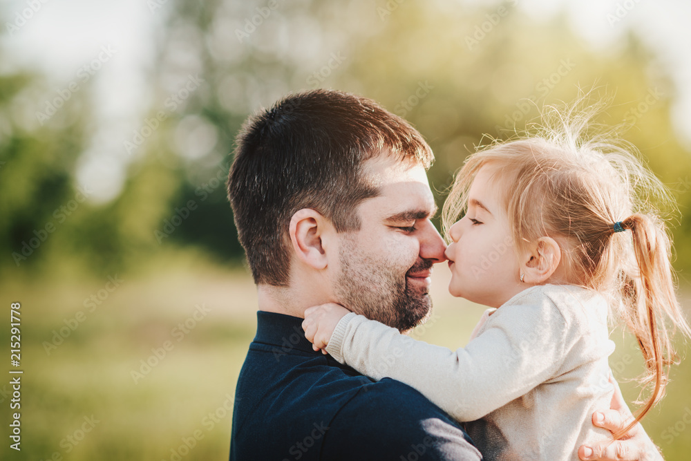 Playful child kissing her father's nose Playful child kissing her father's nose
