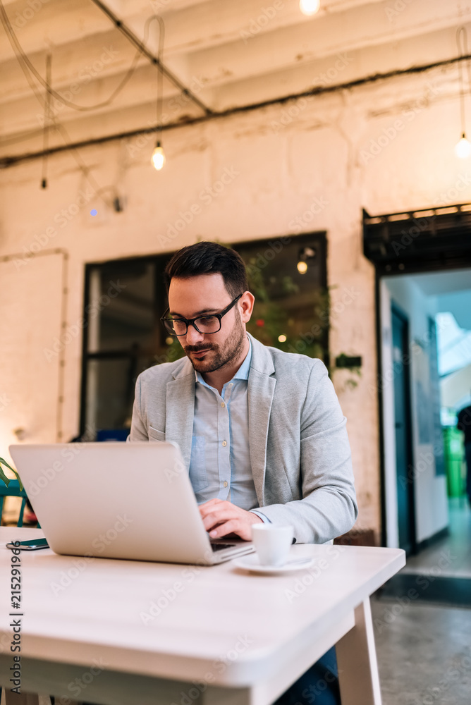Handsome man using laptop at the cafe.