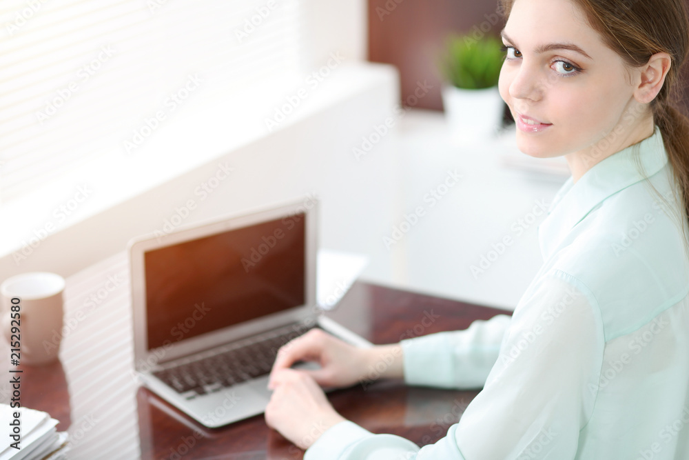 Business woman or secretary sitting at the desk in the office. Green toned image Business woman or secretary sitting at the desk in the office. Green toned image