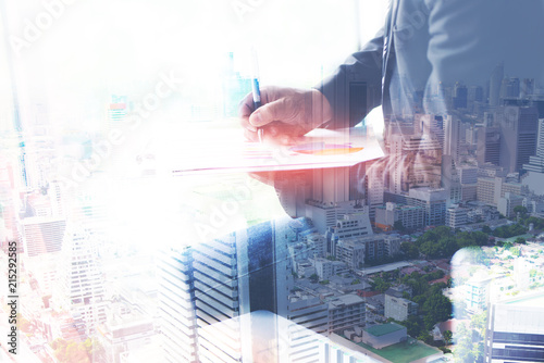 Businessman working on a desk, the concept of double exposure and business capital