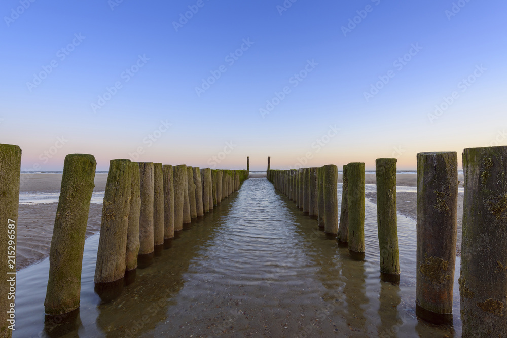 Wooden Breakwater on Beach at Low Tide, Domburg, North Sea, Zeeland, Netherlands Wooden Breakwater on Beach at Low Tide, Domburg, North Sea, Zeeland, Netherlands