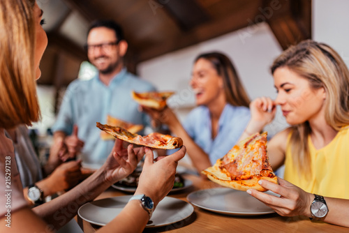 Close-up image of group of friends or colleagues eating pizza. photo