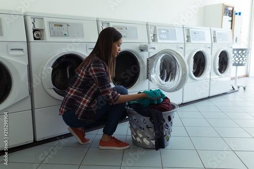 Woman with basket full of clothes in wash house photo