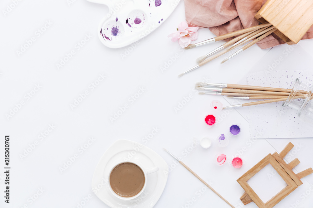 Flat lay composition with brushes, watercolour set and coffee cup on white background. Workspace freelance designer Flat lay composition with brushes, watercolour set and coffee cup on white background. Workspace freelance designer