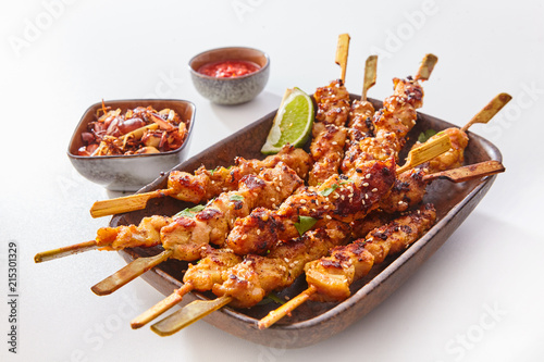 Bild auf Leinwand Dish of Grilled Meat on Wooden Skewers with Lime