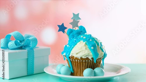 Blue theme colorful novelty cupcake decorated with candy and large heart shaped lollipops for children's or teen's birthday, Valentine's or Fatherr's Day celebrations. photo