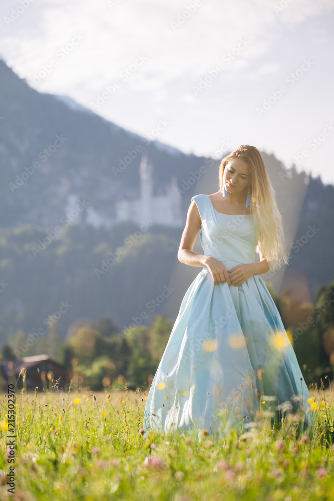 Blond girl in blue dress infront of the castle Blond girl in blue dress infront of the castle