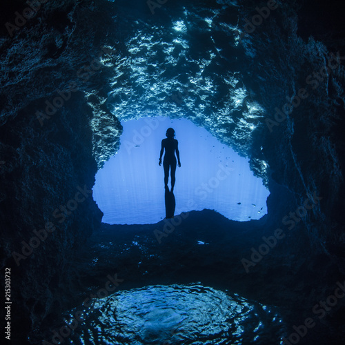 A female free diver divng in the cavern photo