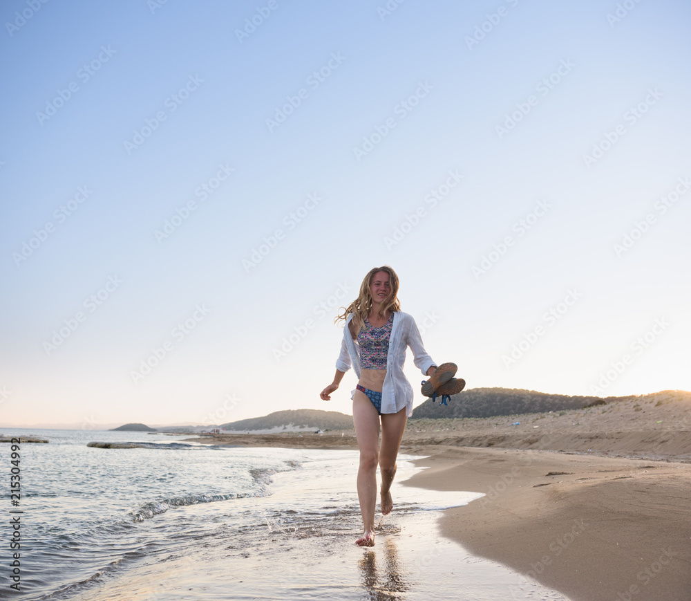 Lively young woman running on the seashore Lively young woman running on the seashore