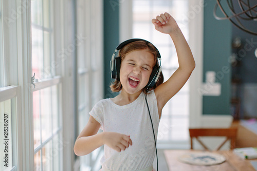 Cute young girl listening to music wearing headphones photo