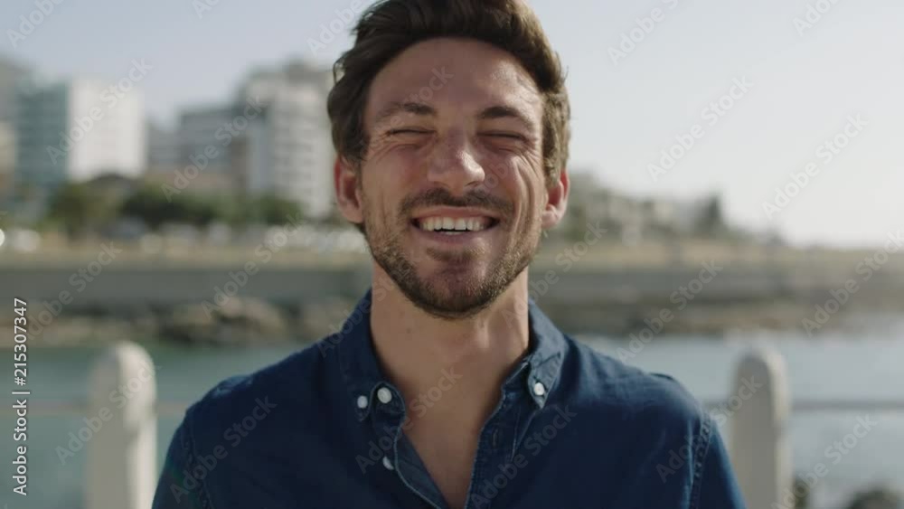 portrait of attractive young man laughing cheerful enjoying relaxed sunny beachfront portrait of attractive young man laughing cheerful enjoying relaxed sunny beachfront